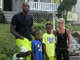 LeBron poses outside the home he renovated with LeBron Jr., Bryce and TVs Rehab Addict host Nicole Curtis.