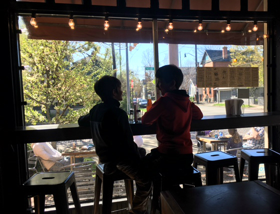 Two boys sit down in The Brown Bag as they wait for their meals. 