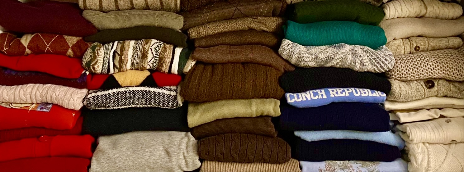 A stack of thrifted sweaters originating from across Columbus. This is a curated collection accrued over one year. They are a trendy winter closet staple.